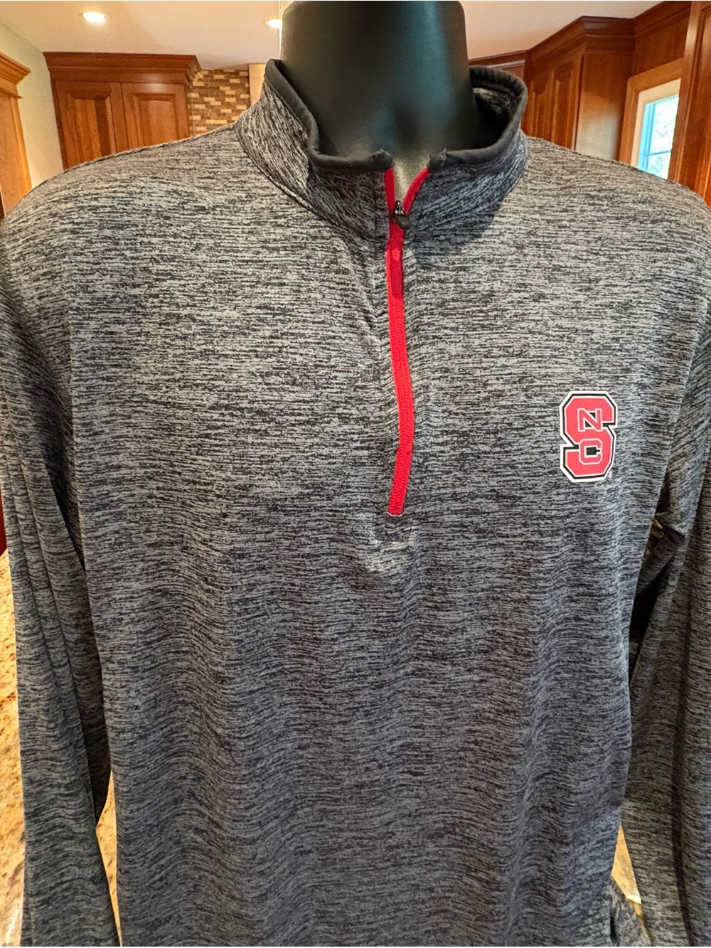 NC State men’s Quarter-Zip Pullover. Sharp grey with NCAA logos on chest & back.